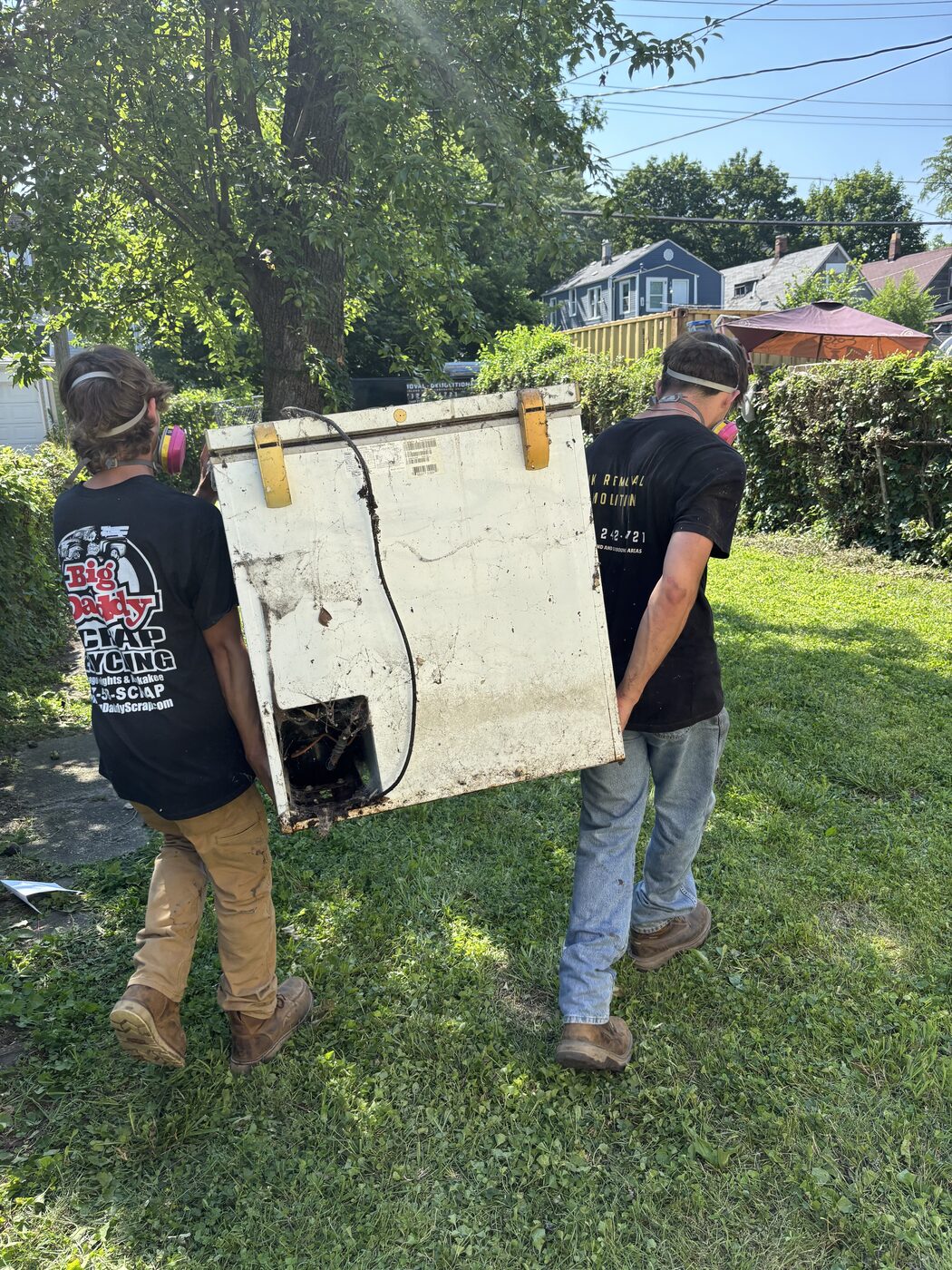 JYD crew carrying an old appliance out for responsible removal