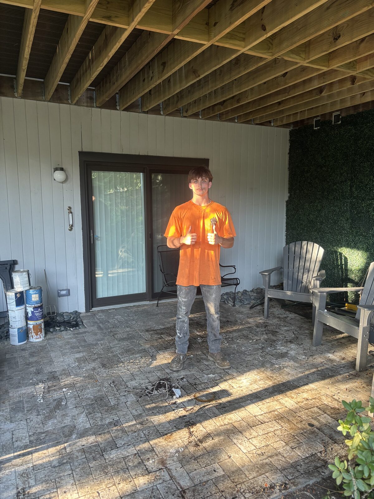 JYD Services crew member after clearing demolition debris from a covered backyard patio
