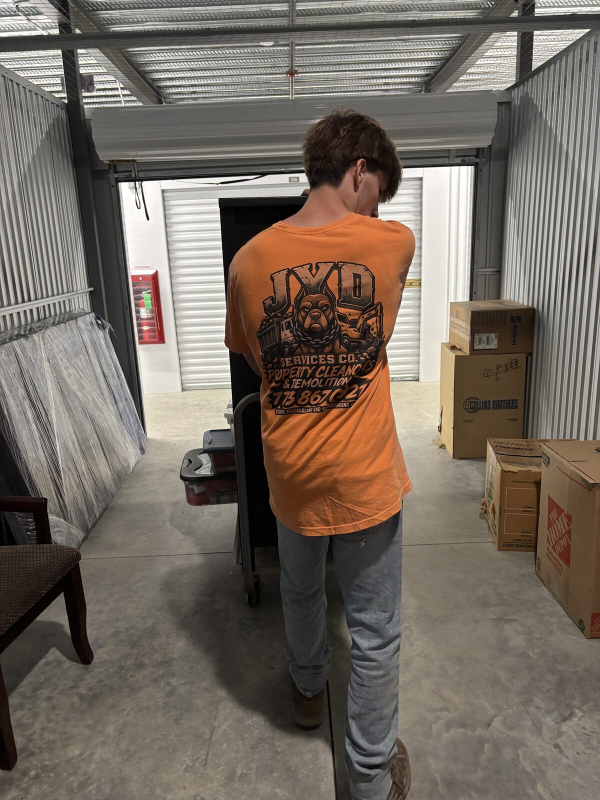 JYD Services crew moving furniture and boxes during a storage unit cleanout